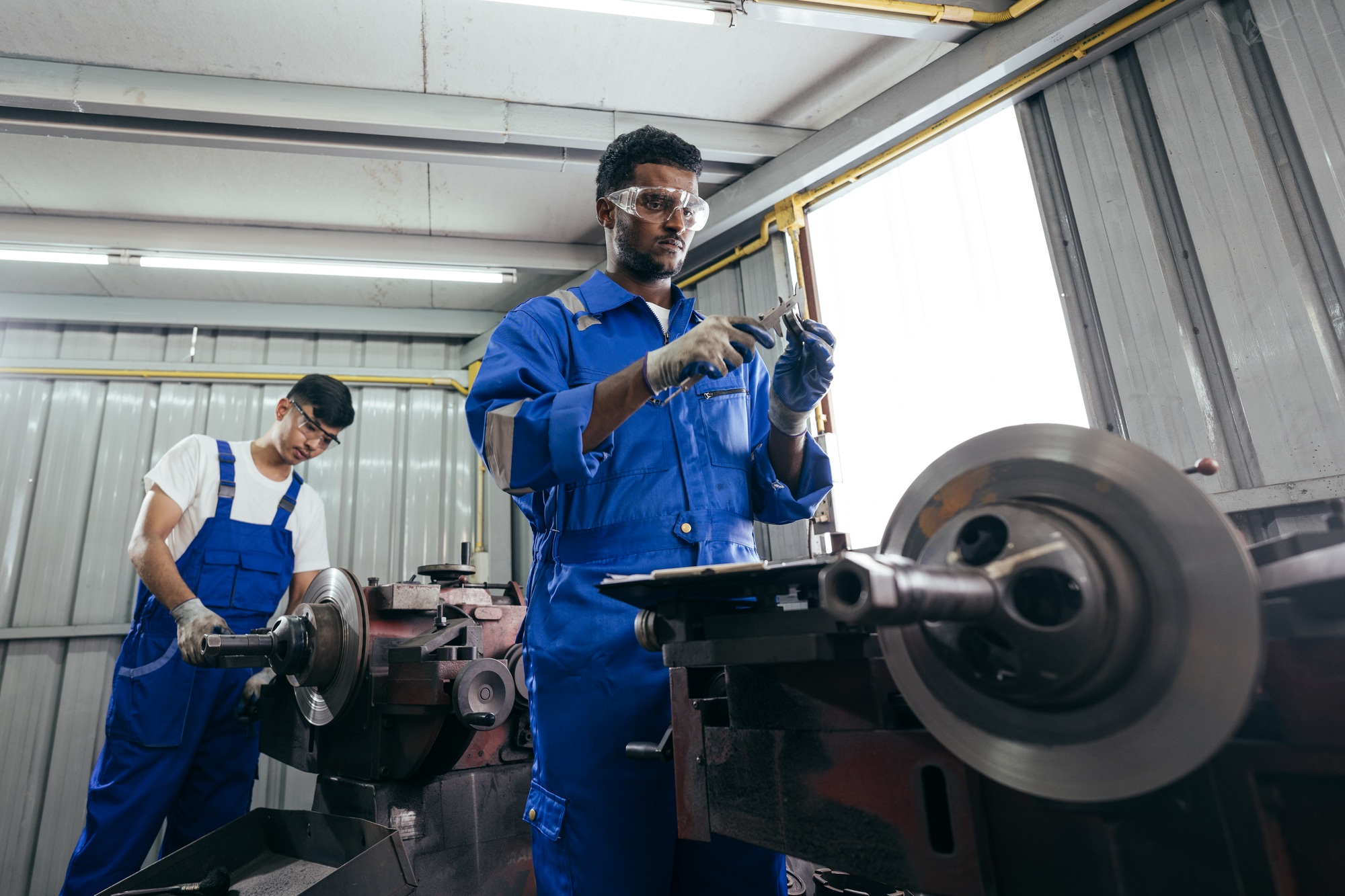 African American mechanic worker inspecting on equipment part at factory