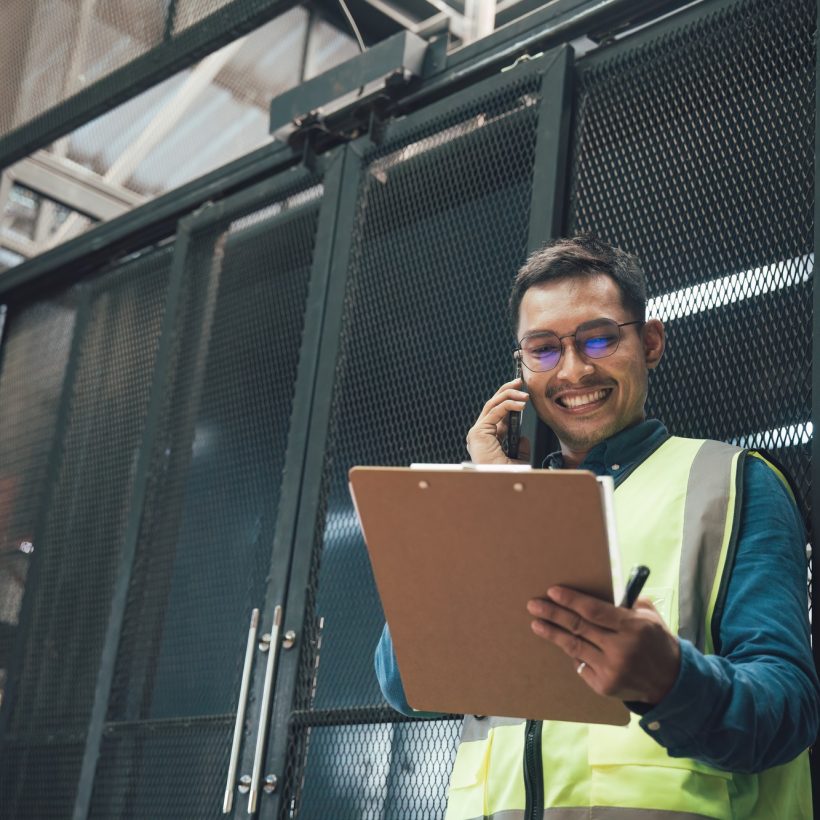 Happy asian male engineer worker enjoy working in factory industry.